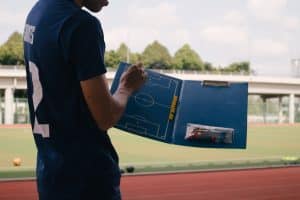 man in blue crew neck t-shirt standing on track field during daytime